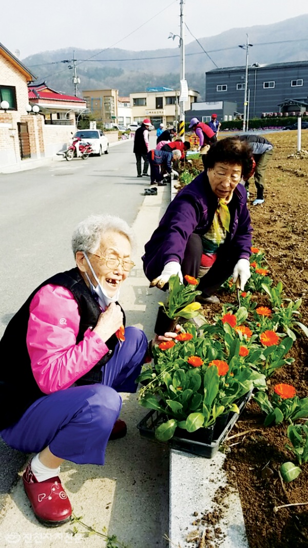 ▲ 마을 미화를 위한 꽃길 조성 활동에 참여한 마을 어르신이 즐겁게 웃고 있다.