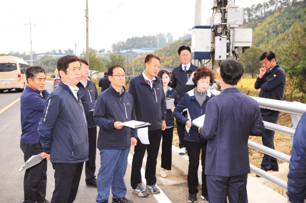 진천군의회 의원들이 건설사업장을 방문해 현지 상황을 듣고 있다.